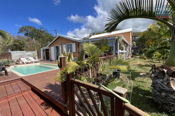 Jolie maison F5 de 175 m2 habitables et 215 m2 utiles avec 2 varangues fermées + piscine au sel chauffée, implantée sur 4579 m2 de terrain pleine vue mer et ravine.